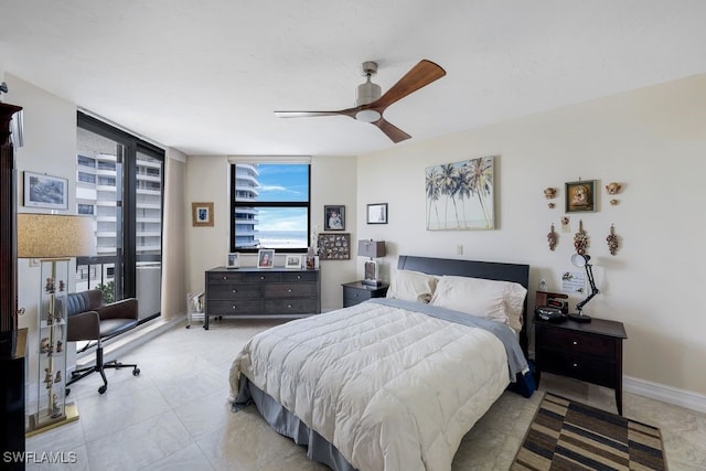 bedroom featuring ceiling fan, light tile patterned floors, and floor to ceiling windows