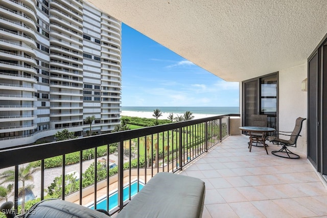 balcony featuring a water view and a pool