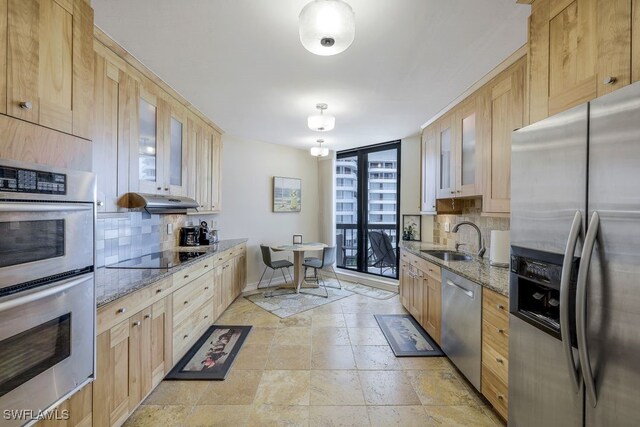 kitchen featuring backsplash, stainless steel appliances, light brown cabinets, and sink