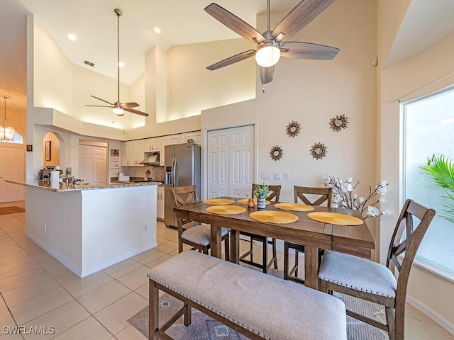 tiled dining area featuring high vaulted ceiling and ceiling fan