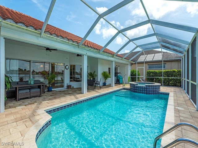 view of swimming pool featuring glass enclosure, an in ground hot tub, ceiling fan, and a patio area