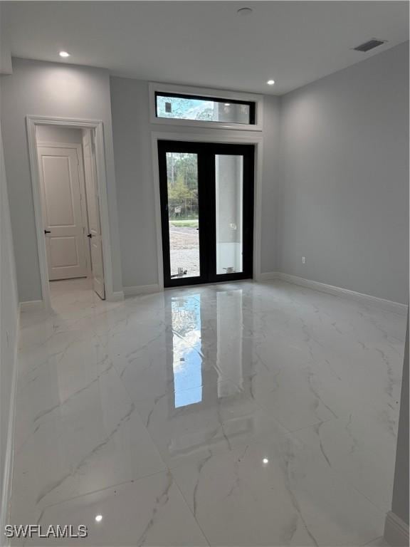 unfurnished room with marble finish floor, baseboards, visible vents, and french doors