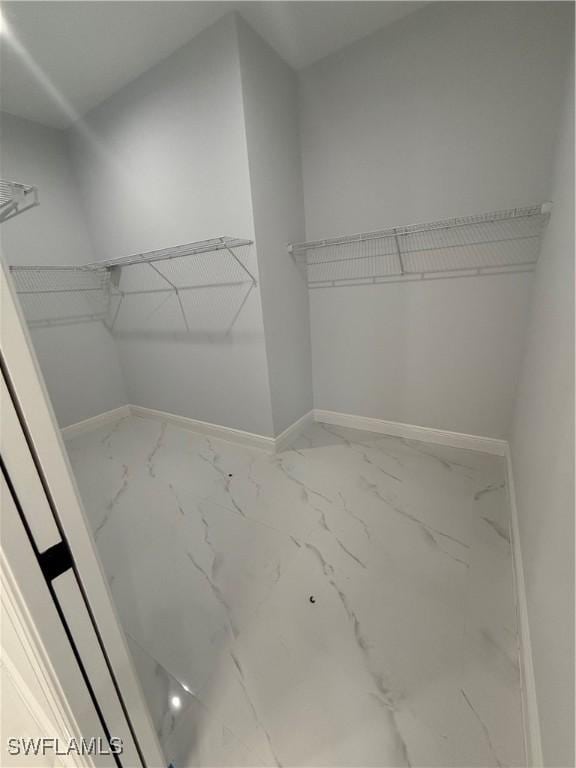 walk in closet with marble finish floor