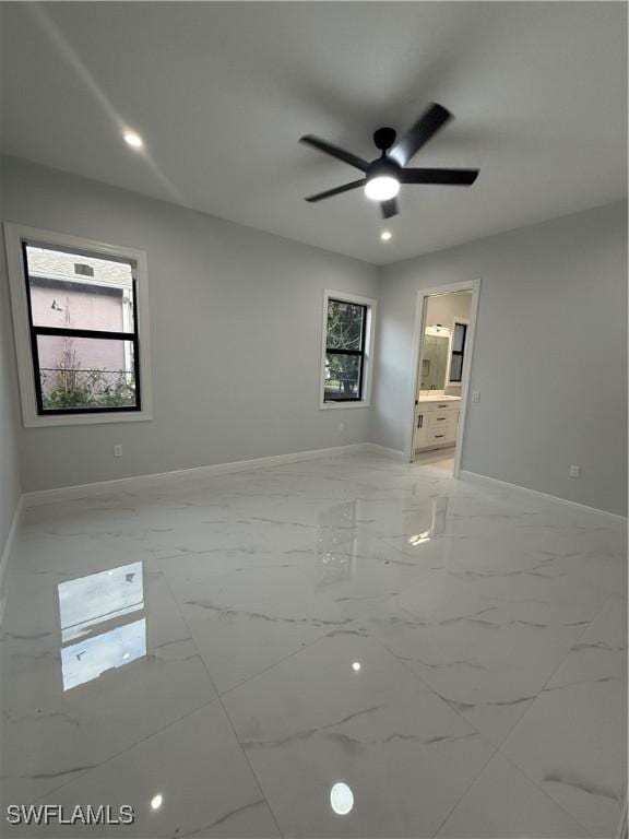 spare room with recessed lighting, marble finish floor, and baseboards