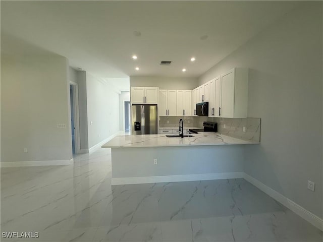 kitchen with visible vents, appliances with stainless steel finishes, a peninsula, marble finish floor, and white cabinetry