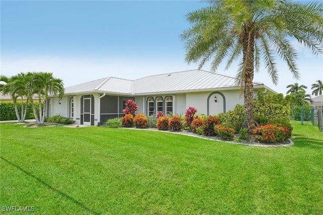 view of front of property with a sunroom and a front yard