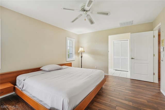 bedroom with a closet, ceiling fan, and dark hardwood / wood-style floors