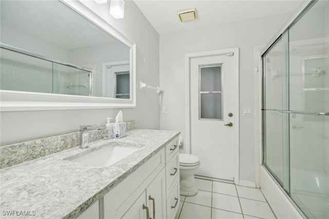 full bathroom featuring tile patterned flooring, vanity, toilet, and combined bath / shower with glass door