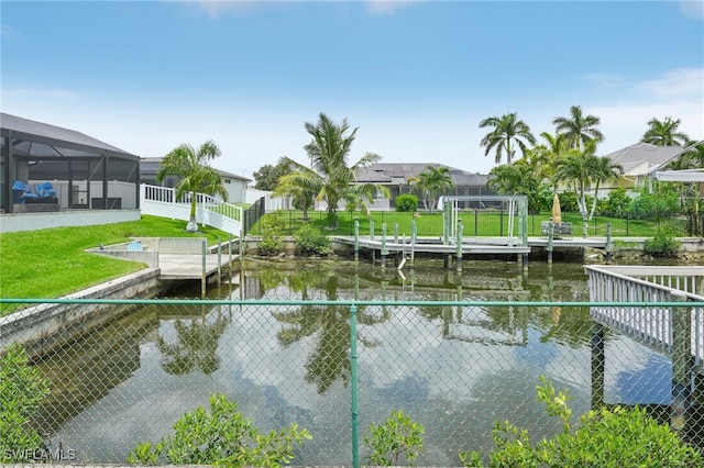 exterior space featuring a boat dock, a lawn, and a water view