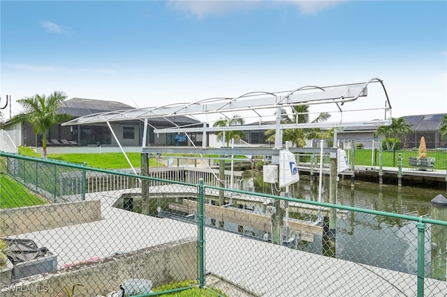 dock area with glass enclosure, a yard, and a water view