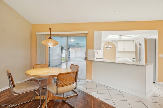 dining room featuring light wood-type flooring, ceiling fan, and sink