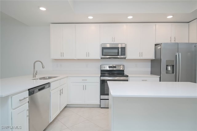 kitchen with sink, white cabinetry, appliances with stainless steel finishes, and light tile patterned flooring