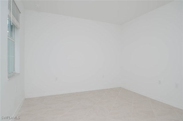 unfurnished room with light tile patterned flooring