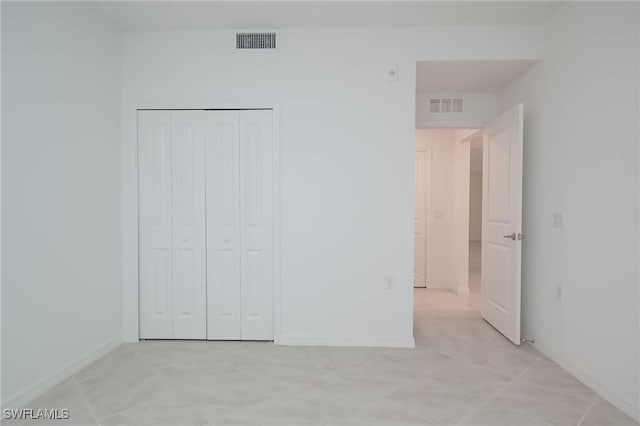 unfurnished bedroom with a closet and light tile patterned floors