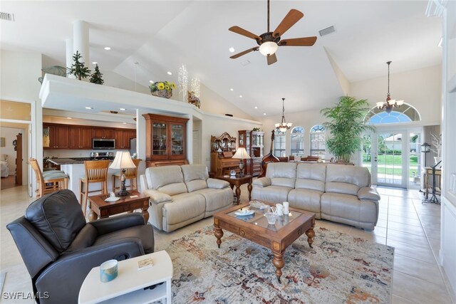 living room with ceiling fan with notable chandelier, high vaulted ceiling, and light tile patterned floors