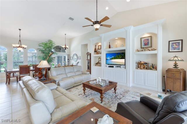 living room featuring ceiling fan with notable chandelier, built in features, vaulted ceiling, and light tile patterned flooring