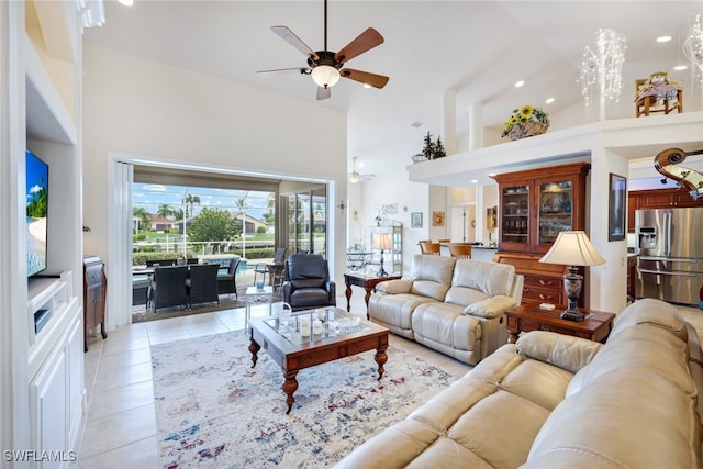 living room featuring light tile patterned floors, a ceiling fan, and a towering ceiling