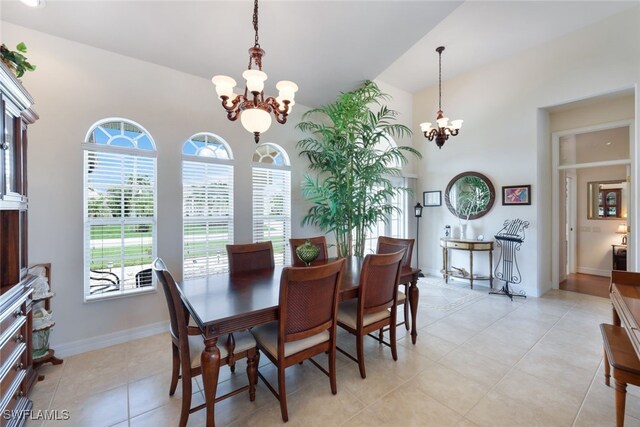 dining area with vaulted ceiling, an inviting chandelier, and light tile patterned floors