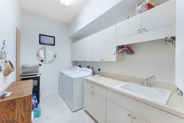 laundry room with cabinets, washing machine and dryer, sink, and light tile patterned flooring