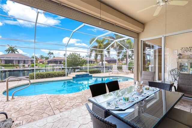 view of swimming pool with a water view, ceiling fan, a lanai, and a patio