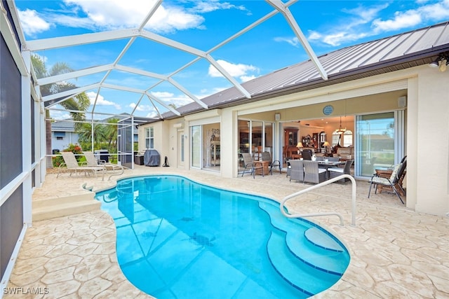 view of swimming pool with glass enclosure and a patio