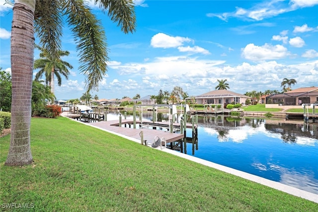 dock area featuring boat lift, a lawn, and a water view