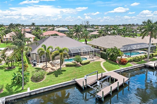 dock area with a lanai, a water view, a lawn, and a patio