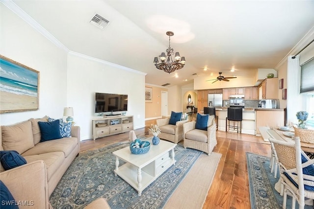 living room featuring lofted ceiling, ornamental molding, a chandelier, and wood-type flooring