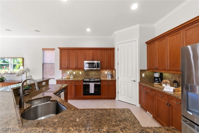 kitchen with dark stone counters, light tile patterned flooring, sink, appliances with stainless steel finishes, and ornamental molding