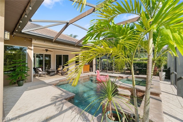 view of pool with ceiling fan, glass enclosure, and a patio