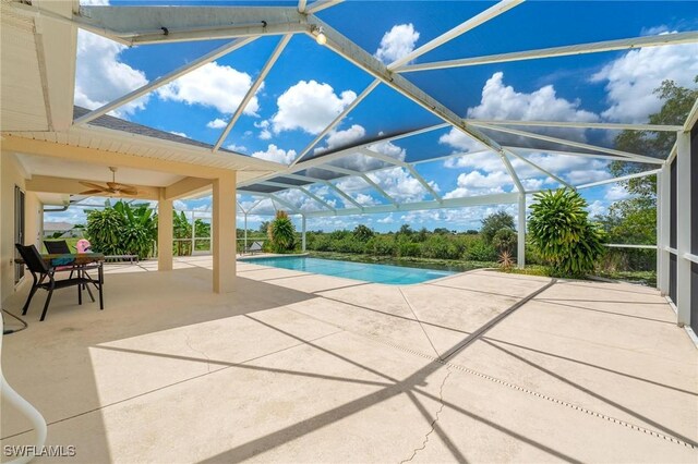 view of swimming pool featuring a patio area, ceiling fan, and glass enclosure