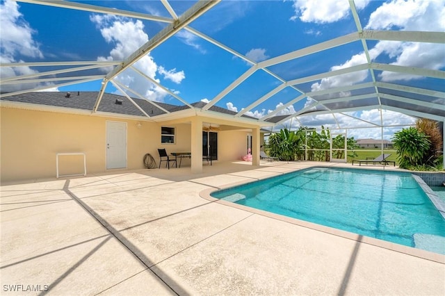 view of pool featuring a patio, ceiling fan, and glass enclosure