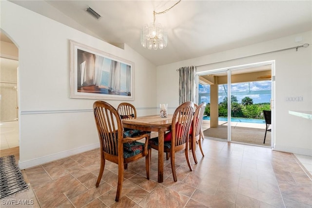 dining space featuring vaulted ceiling and an inviting chandelier