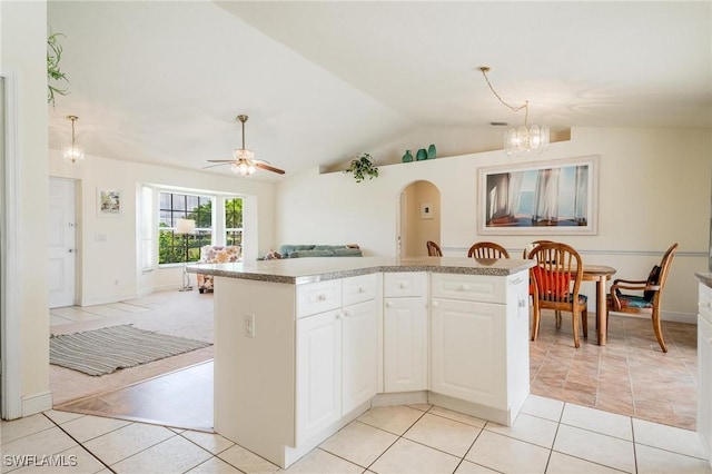 kitchen with light tile patterned floors, decorative light fixtures, vaulted ceiling, and white cabinets