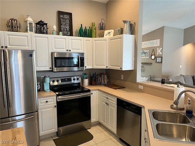 kitchen featuring light tile patterned flooring, appliances with stainless steel finishes, sink, and white cabinetry