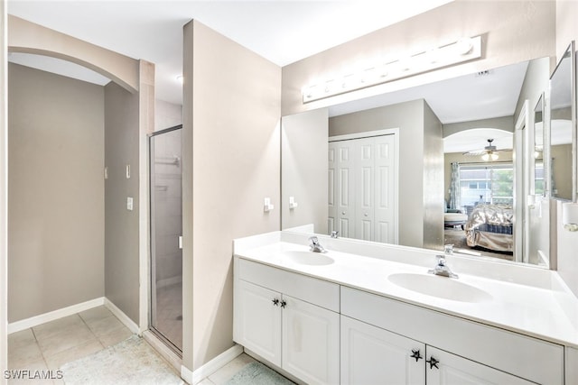 bathroom featuring ceiling fan, vanity, a shower with door, and tile patterned floors