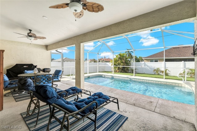 view of swimming pool with glass enclosure, area for grilling, ceiling fan, and a patio area