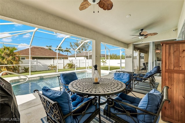 view of patio with glass enclosure, ceiling fan, and a fenced in pool