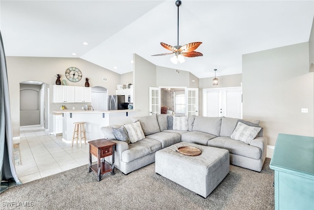 living room featuring ceiling fan, light colored carpet, and high vaulted ceiling