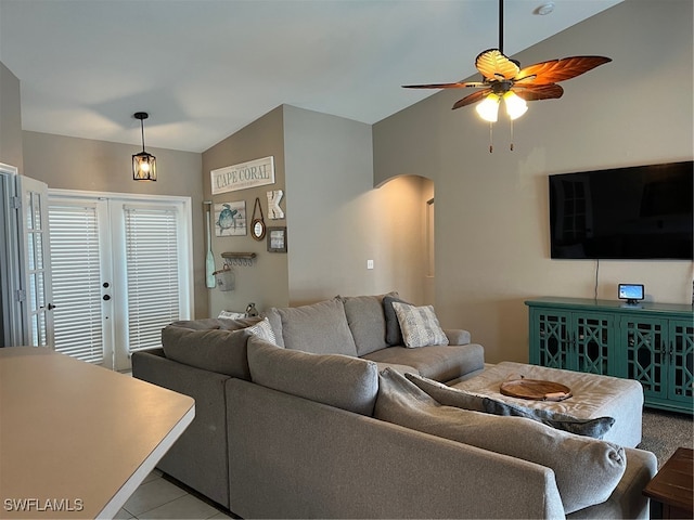 living room featuring lofted ceiling, ceiling fan, and light tile patterned flooring