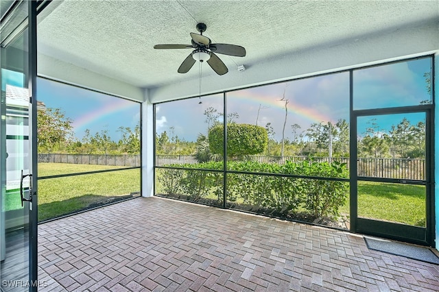 unfurnished sunroom featuring a ceiling fan