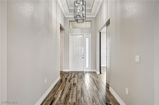 corridor featuring crown molding, a notable chandelier, a high ceiling, and hardwood / wood-style floors