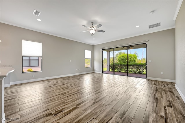 spare room with light hardwood / wood-style flooring, ceiling fan, and crown molding