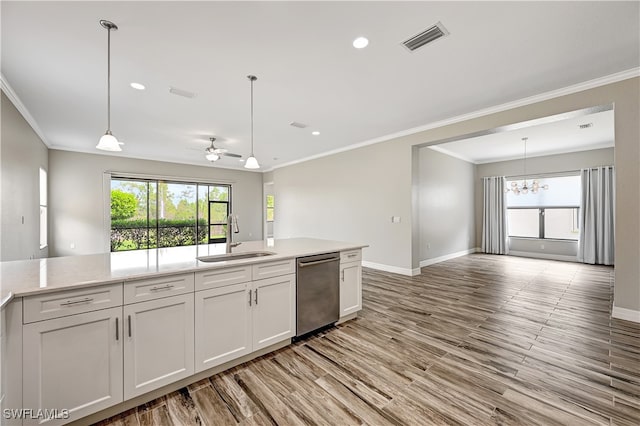 kitchen featuring sink, light wood-type flooring, pendant lighting, stainless steel dishwasher, and white cabinets