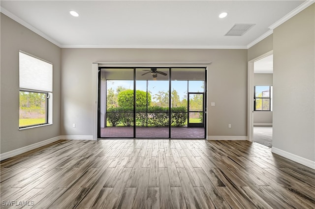 spare room with crown molding, hardwood / wood-style floors, and a healthy amount of sunlight