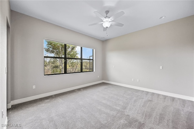 empty room featuring ceiling fan and carpet