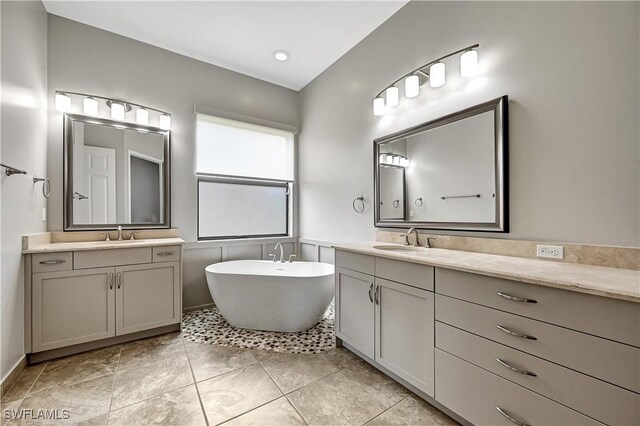 bathroom featuring vanity, a bath, and tile patterned flooring