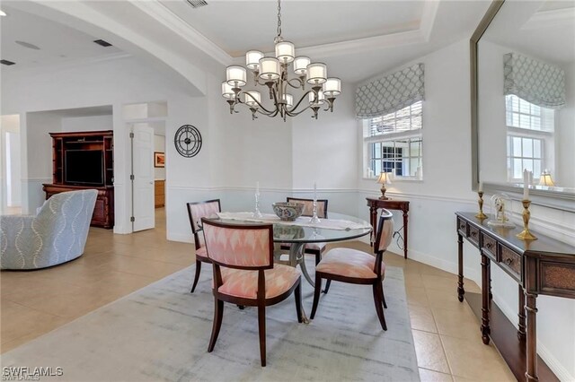 dining room featuring arched walkways, light tile patterned flooring, visible vents, ornamental molding, and an inviting chandelier