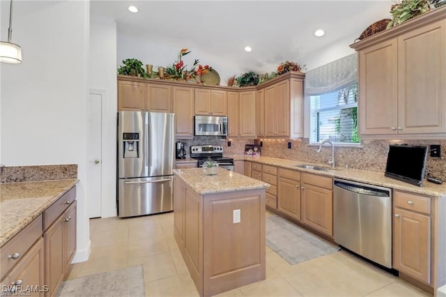 kitchen featuring tasteful backsplash, a kitchen island, appliances with stainless steel finishes, light stone counters, and a sink