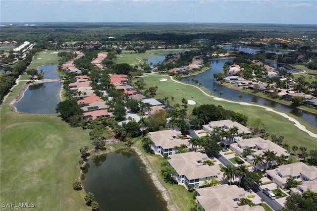 drone / aerial view featuring golf course view, a water view, and a residential view